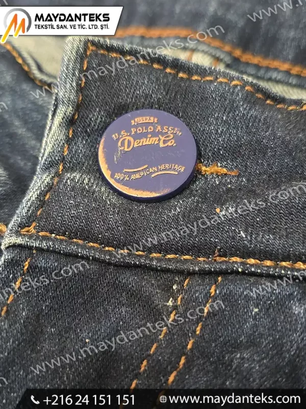 Bouton métallique rond finition mate pour jeans en denim avec couture apparente