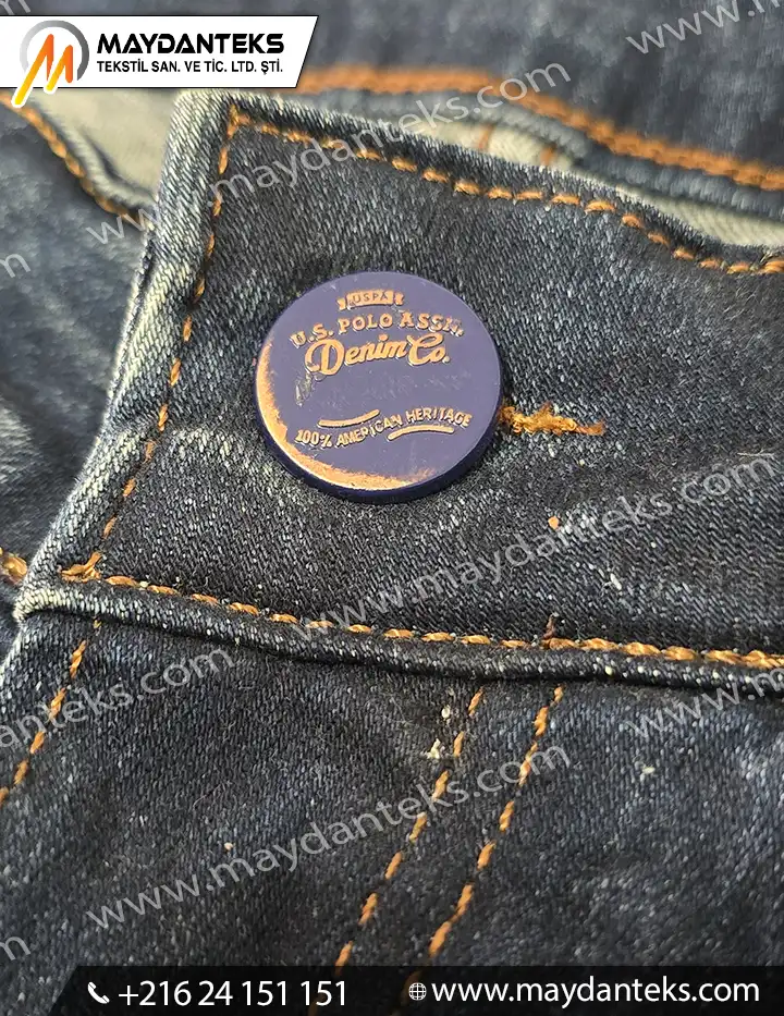 Bouton métallique rond finition mate pour jeans en denim avec couture apparente