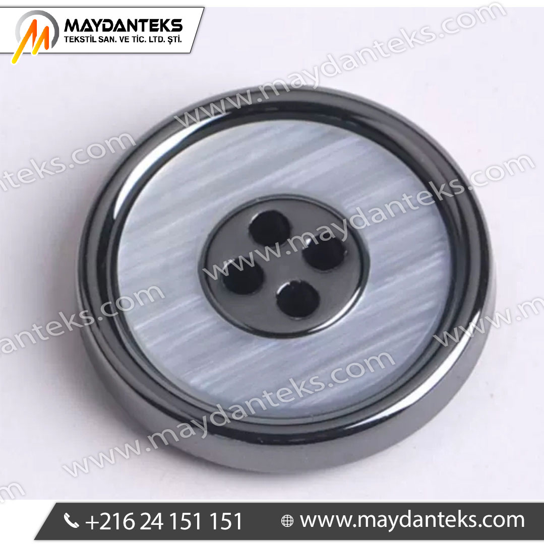 Un bouton élégant pour des créations haut de gamme Ce bouton métal gunmetal avec centre nacré gris offre une alternative plus subtile aux designs très contrastés. Il apporte une finition sophistiquée sans être trop visuel, parfait pour des collections élégantes et intemporelles. Un contraste doux et raffiné Le métal gunmetal structure le design tandis que le centre nacré capte la lumière avec finesse. Ce jeu de textures crée un effet premium discret, très apprécié dans le tailoring et la mode contemporaine. Une conception robuste et durable Pensé pour un usage professionnel : • Structure métallique résistante aux chocs • Résine nacrée résistante aux rayures • Bonne tenue aux lavages répétés • Stabilité visuelle dans le temps Fixation fiable et adaptée à la confection La configuration 4 trous assure une couture solide, idéale pour les vêtements soumis à tension ou à usage fréquent. Applications idéales • Vestes de costume et blazers • Manteaux et trench-coats • Mode masculine et féminine élégante • Uniformes premium • Accessoires textile et maroquinerie Un choix stratégique pour marques premium Ce bouton permet d’augmenter la valeur perçue d’un produit tout en restant sobre. Il est idéal pour des collections visant un positionnement haut de gamme sans effet “bling”. Caractéristiques techniques Matière : Alliage métallique + résine nacrée Type : Bouton 4 trous Finition : Gunmetal brillant + centre gris perlé Structure : Bicolore avec insert nacré Fixation : Couture standard Résistance : Choc, usure, lavage Positionnement : Premium / élégant